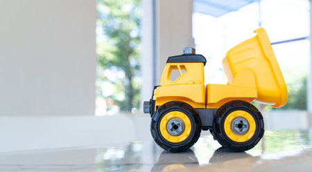 Dump truck, yellow construction toy vehicle with articulated parts built with sturdy plastic is...