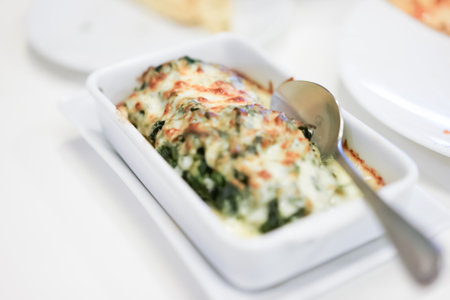 Baked spinach with cheese is easily made by smothering the spinach in cheese sauce and baking it until golden and bubblyの写真素材