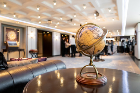 An elegant vintage classic world map model placed on a retro circle dark wood table in the hotel lobby.の写真素材