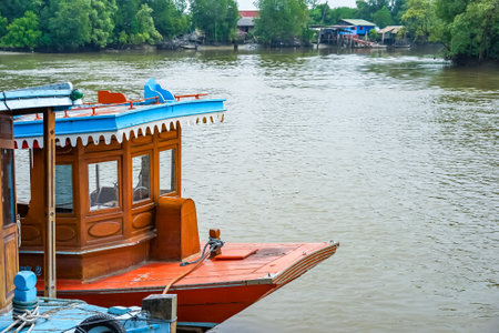 The prow of the Thai style vintage wooden boat floating on the water of a river in Hua Hin, Thailand.の写真素材