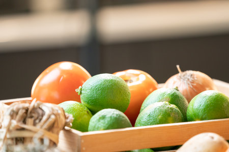 close up fresh green lime and tomato in glass bowl in studio light at kitchen.の写真素材