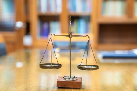 Old Brass Law Scale vintage style is laid on wood glass table in Lawyer office meeting room.の写真素材