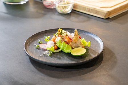 Spicy Raw Salmon Salad Thai food style decorated with Crispy fried fish skin and Yellow Flower on top and micro herb around dish. Ready to serve and eat.の写真素材