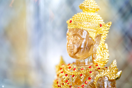 Transparent crystal Buddha in Gold suit with blur bokeh shining background.の写真素材