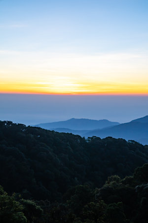 The beautiful sunrise at Doi intanon national park, Chiang Mai in the morning.Sun is rising from the hill to shy with beautiful yellow orange light.の写真素材
