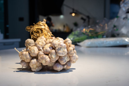 Garlic Bundle in studio light on the white marble surface table, prepare for a food demonstration behind.の写真素材