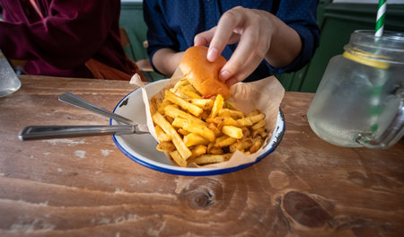 a grilled beef cheeseburger topped with gooey cheddar and a side of crispy French fries shines in...
