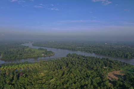 Daytime aerial view Bang Pakong river in Chachoengsao province, Thailand. Bang Pakong River landscape view at Chachoengsao by the greenery forest and harbor riverside.の写真素材