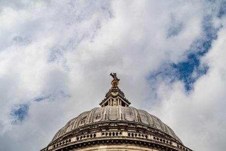 The upper dome of the Cathedral of St Paul, a masterpiece of English Baroque design, stands tall against the dramatic clouds.の写真素材