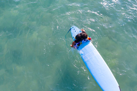 Drone view of Asian Surf board man plays surf in the sea beach at Kata Beach, Phuket Thailand.