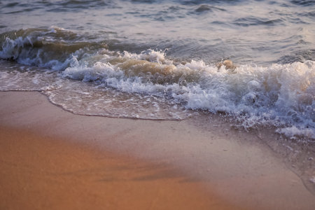 The beautiful scene of Pattaya beach and sea waves with the golden sun and white clouds on the clear...