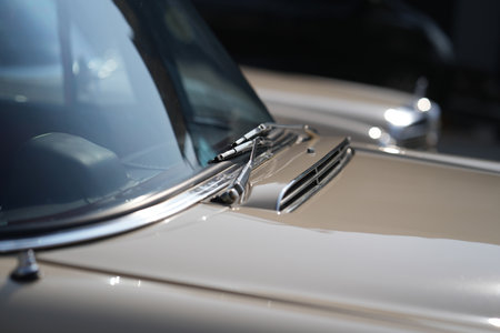 The windshield and chrome wipers of a classic car showcase the timeless allure of vintage automotive design, with their glossy finish and detailed craftsmanship sparking nostalgia for a past era.の写真素材