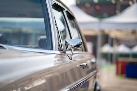 The side mirror of the classic car shines brightly, reflecting its vintage charm and polished...