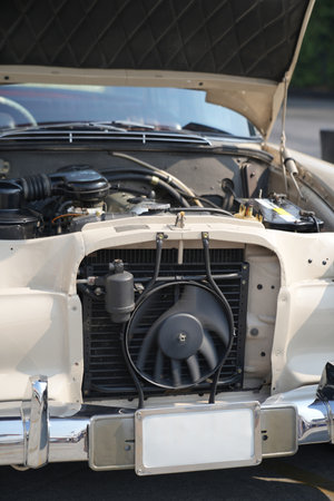 The engine and battery compartment of a classic car, with its detailed mechanical and electrical...