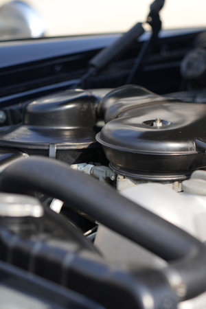 The engine and battery compartment of a classic car, with its detailed mechanical and electrical...