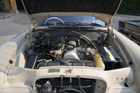 The engine and battery compartment of a classic car, with its detailed mechanical and electrical...