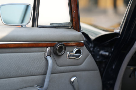 The inner door handles of a vintage car are captured in a clean view, reflecting the classic design and preserved components that represent the simplicity and authenticity of vintage cars.の写真素材