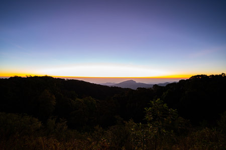 The beautiful sunrise at Doi intanon national park, Chiang Mai in the morning.Sun is rising from the hill to shy with beautiful yellow orange light.の写真素材
