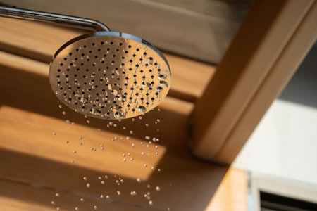 Close up to Outdoor shower head for the bath and showering cold water to body before jumping in the resort pool.の写真素材
