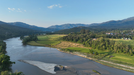 Aerial view of terraced agriculture field among greenery mountains with the blue cloudy and sunlight...