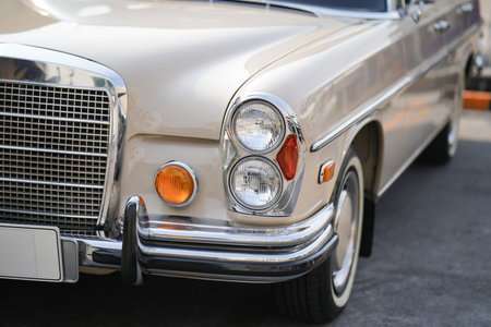 The round headlights and side turn signals on classic cars, framed in polished chrome, highlight the...