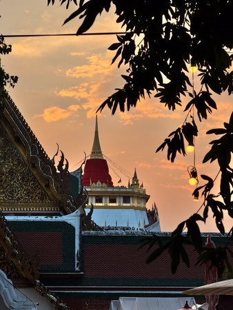 The Golden Mount Temple shines under a warm sunset sky in Bangkok reflecting peace faith and beauty...