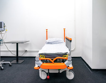 Bed with orange bed rails, it is able to be temporarily moved everywhere. This place has an equipment disinfection.の写真素材
