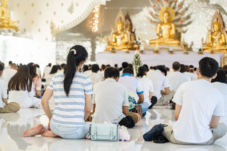 Portrait of people are meditating on Buddhist practices in the temple. People sit for meditation with peace and relax at temple or church and wearing white clothes.の写真素材