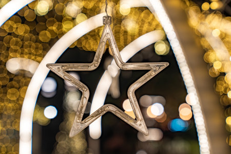 A star shaped clear light appears against warm golden bokeh, and the glowing circles form a gentle festive mood.の写真素材