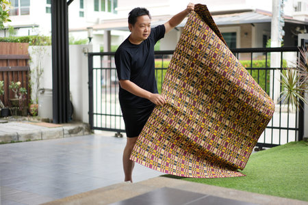 Home Preparation Mindset, He unfolds a mat with care, beginning his day with focus and quiet preparation.の写真素材