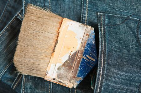 Old paint brush in a jeans pocket の写真素材