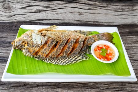 Fried  tilapia fish with spicy sauceの写真素材