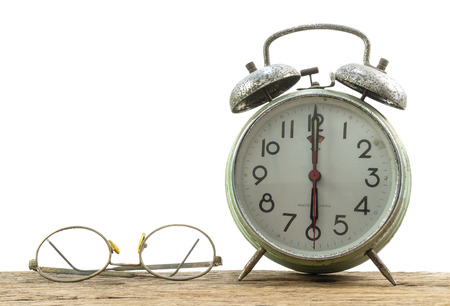 Old glasses and old green clock alarm on white backgroundの写真素材