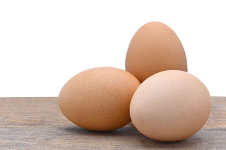 three chicken eggs on old wood and white background close upの写真素材