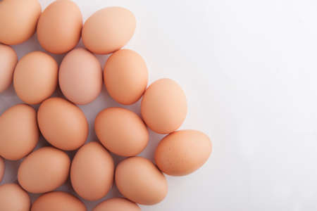 many fresh brown eggs   on white background