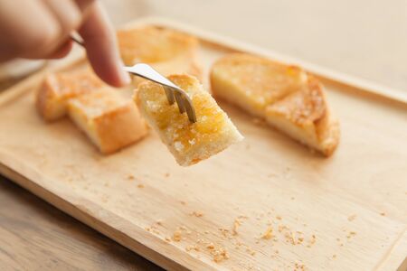 Toast bread with butter in wood plate
