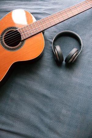 Acoustic guitar resting against a fabric background with copy spaceの写真素材