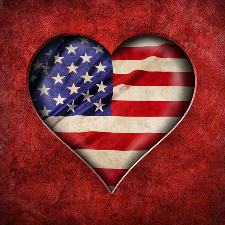 Heart shape cut out of red fabric on United States of grunge America flagの写真素材