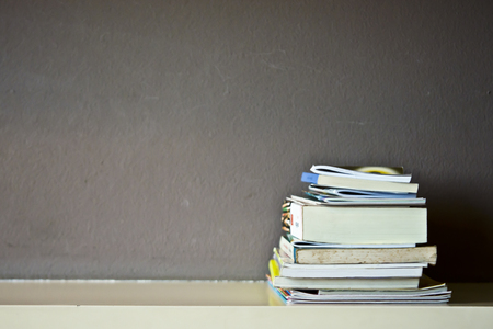 Book stack on a shelf with shade lightingの写真素材