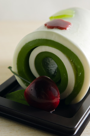 Fancy soap in cake form with cherry on wooden board backgroundの写真素材