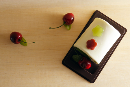 Fancy soap in cake form with cherry on the top on wooden board backgroundの写真素材
