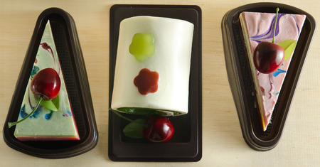 Fancy soap in cake form with cherry on the top on wooden board backgroundの写真素材