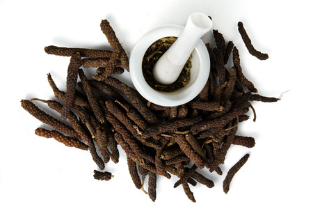 Long black pepper (Also called as Pipli in Indian, capsicum frutescens, Balinese pepper, Jaborandi pepper, Bengal pepper, Dipli in Thai, Piper longum) with mortar isolated on white backgroundの写真素材
