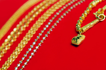 Gold necklace 96.5 precent Thai gold design with gold heart pendant isolated on red flannel cloth background with blank text copy spaceの写真素材