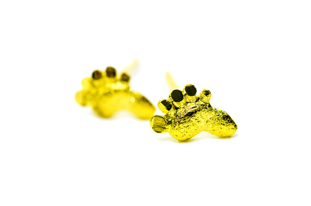 Gold pendant cameo earring jewellery with special Thai gold design in foot shape isolated on white backgroundの写真素材