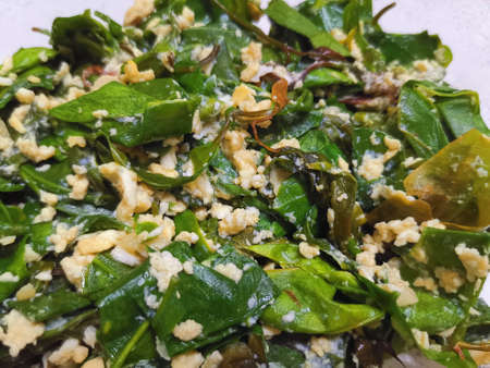 Stir-fried Malindjo Leaves with Egg on the white plate