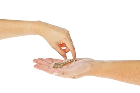 Old golden key picked up from hand to hand isolated on white backgroundの写真素材