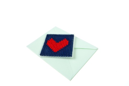 Green envelop with red knitted heart isolated on white backgroundの写真素材