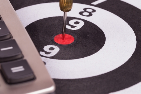 bulls eye target with dart and calculator