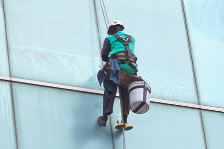 A worker cleaning windows service on high rise buildingの写真素材